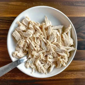 Creamy shredded chicken served in a bowl with herbs and spices