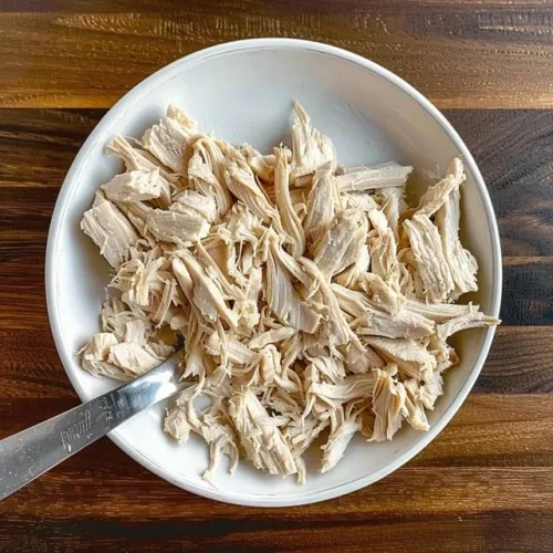 Creamy shredded chicken served in a bowl with herbs and spices