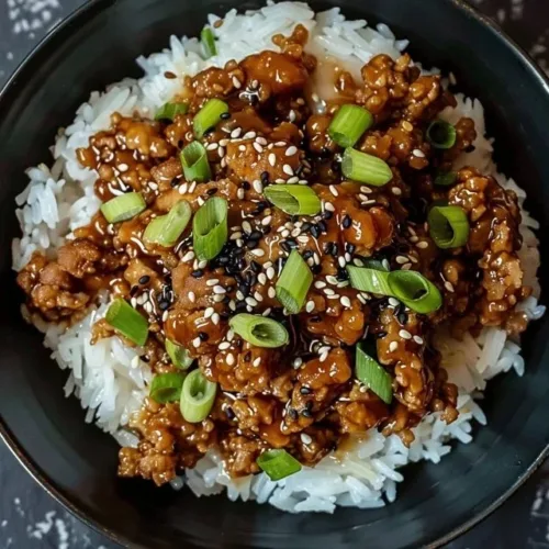 Delicious Sesame Ground Chicken Bowl topped with sesame seeds and fresh vegetables.